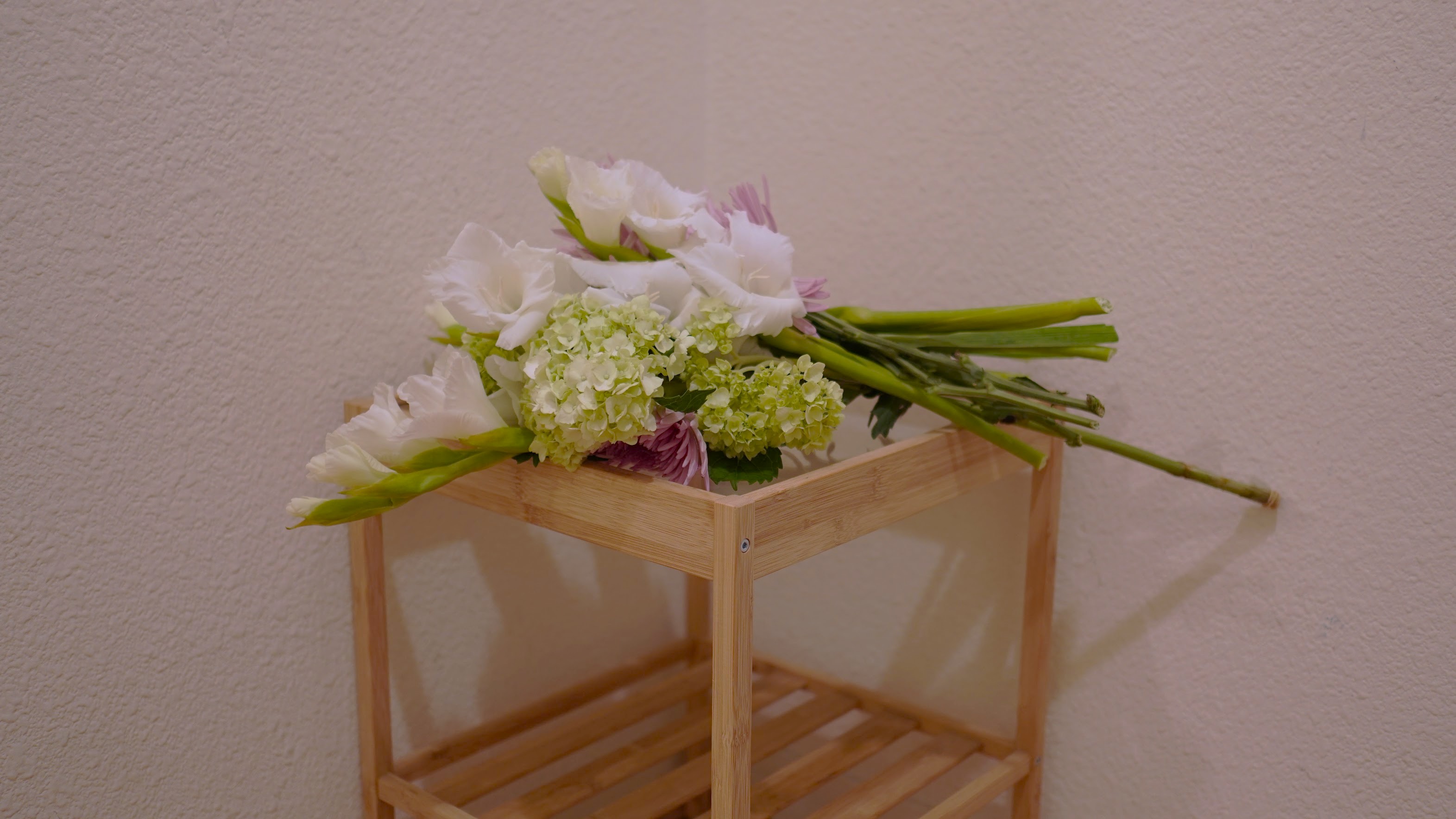 A white bouquet resting on a wooden bench, June 2017